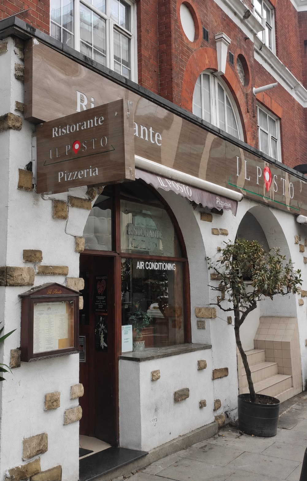 The corner entrance of Il Posto Ristorante Pizzeria in Victoria, London